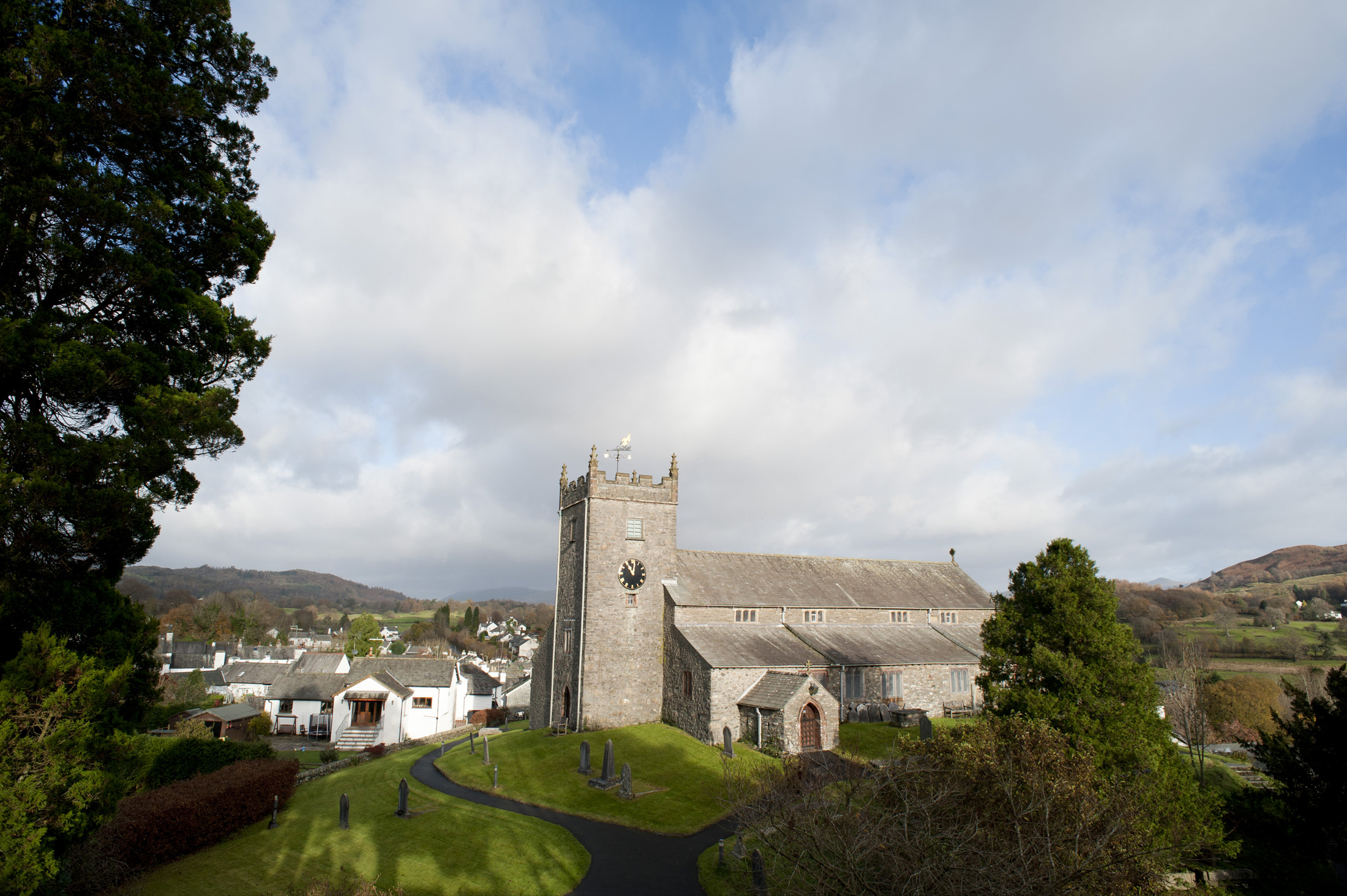 an image of View between trees of Hawkshead Church in the picturesque village of Hawkshead in the Lake District in Cumbria